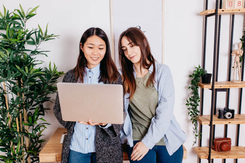 chicas de pie viendo la computadora