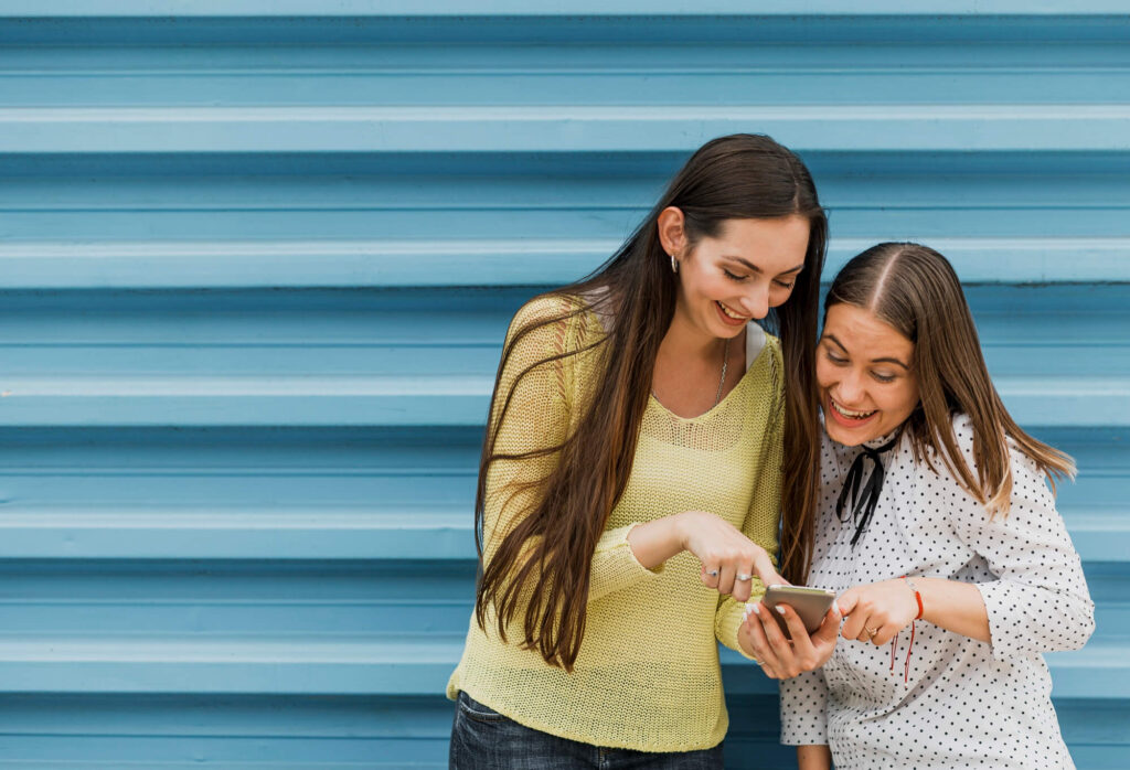 Personas en la calle con celular en mano