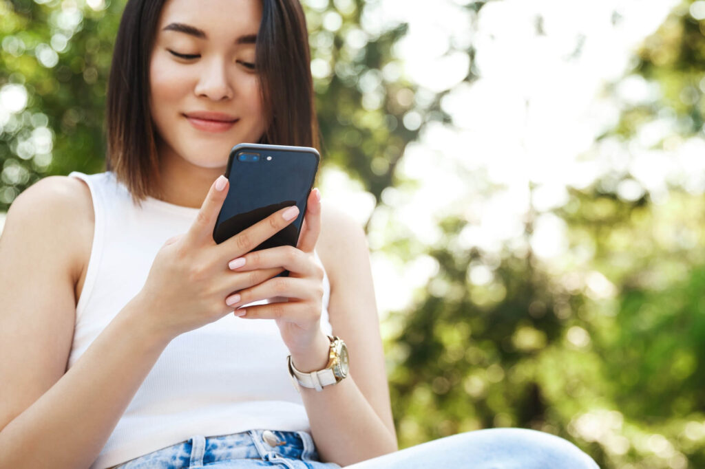 chica mirando el celular al aire libre