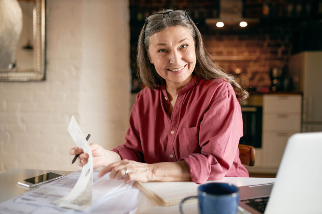 Señora sonriendo con papeles en mano