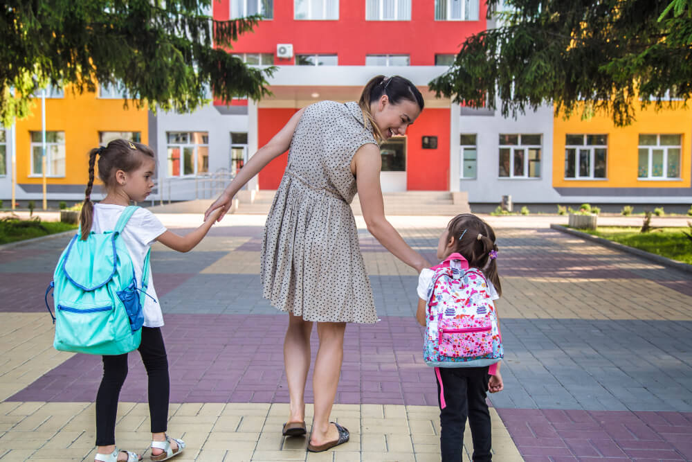 niñas yendo a la escuela con su mamá